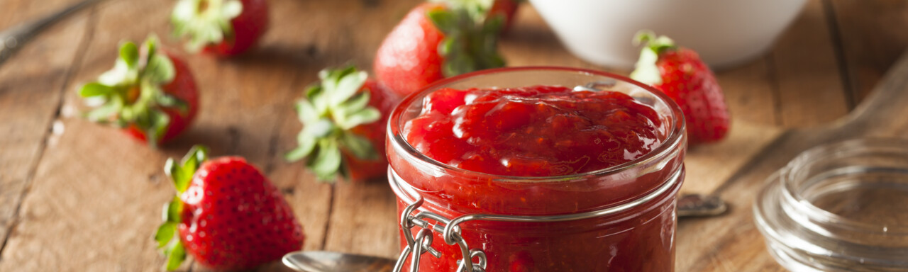 Erdbeermarmelade im Glas mit frischen Erdbeeren | © AdobeStock_80764959